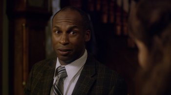 Movie still from “Turkey Hollow” (2015), directed by Kirk R. Thatcher – A man in a suit and tie looking to his left; Close Up shot, Over the shoulder angle