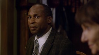 Movie still from “Turkey Hollow” (2015), directed by Kirk R. Thatcher – A man in a suit and tie looking to his left; Close Up shot, Over the shoulder angle