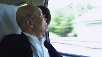 Movie still from “Jiro Dreams of Sushi” (2011), directed by David Gelb – An older man sitting in a car looking out the window; Close Up shot, Low angle