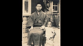 Movie still from “Jiro Dreams of Sushi” (2011), directed by David Gelb – An old photo of a man and a young child; Medium shot, High angle