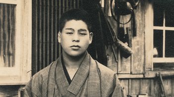 Movie still from “Jiro Dreams of Sushi” (2011), directed by David Gelb – An old photo of a young man in a kimono; Extreme Close Up shot, Low angle