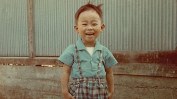 Movie still from “Jiro Dreams of Sushi” (2011), directed by David Gelb – A little boy that is standing up in a yard; Medium shot, Overhead angle