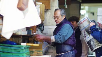 Movie still from “Jiro Dreams of Sushi” (2011), directed by David Gelb – An older man is working in a store; Medium shot, Low angle