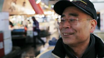 Movie still from “Jiro Dreams of Sushi” (2011), directed by David Gelb – An older man wearing glasses and a hat; Close Up shot, Low angle