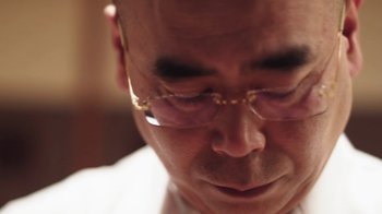 Movie still from “Jiro Dreams of Sushi” (2011), directed by David Gelb – A person wearing glasses; Extreme Close Up shot, Low angle