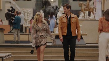 Movie still from “Emily in Paris” (2020), created by Darren Star – A man and a woman are holding hands while standing in front of statues; Wide shot, Over the shoulder angle