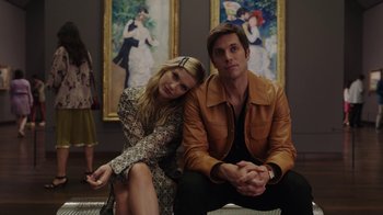 Movie still from “Emily in Paris” (2020), created by Darren Star – A man and a woman sitting next to each other; Medium shot, Low angle