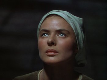 Movie still from “Joan of Arc” (1948), directed by Victor Fleming – A woman wearing a head scarf looking upward; Close Up shot, Low angle