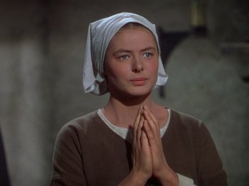 Movie still from “Joan of Arc” (1948), directed by Victor Fleming – A woman with her hands folded in front of her face; Close Up shot, Low angle