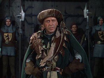 Movie still from “Joan of Arc” (1948), directed by Victor Fleming – A man dressed as a medieval character in a costume; Medium shot, Over the shoulder angle