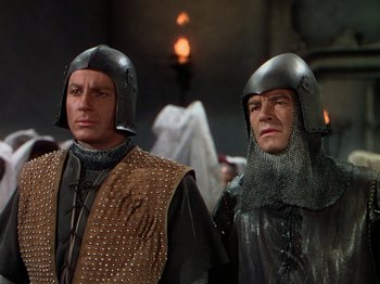 Movie still from “Joan of Arc” (1948), directed by Victor Fleming – Two men in medieval costumes standing next to each other; Medium shot, Low angle