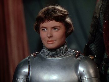 Movie still from “Joan of Arc” (1948), directed by Victor Fleming – A woman wearing a suit of armor in front of a wall; Close Up shot, Low angle