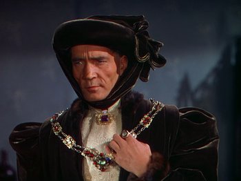 Movie still from “Joan of Arc” (1948), directed by Victor Fleming – A person wearing a suit and a crown; Close Up shot, Over the shoulder angle