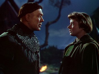 Movie still from “Joan of Arc” (1948), directed by Victor Fleming – A man and a woman standing next to each other in front of a tree; Medium shot, Low angle