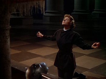 Movie still from “Joan of Arc” (1948), directed by Victor Fleming – A woman standing on the ground with her arms outstretched; Medium shot, Low angle