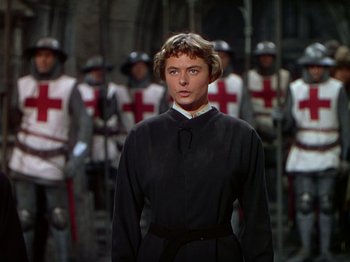 Movie still from “Joan of Arc” (1948), directed by Victor Fleming – A woman standing in front of a group of men in uniforms; Medium shot, Over the shoulder angle