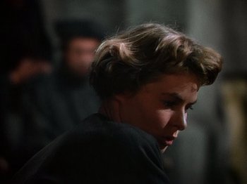 Movie still from “Joan of Arc” (1948), directed by Victor Fleming – A young man with short brown hair wearing a black shirt; Close Up shot, Over the shoulder angle