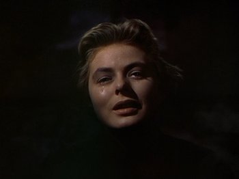 Movie still from “Joan of Arc” (1948), directed by Victor Fleming – A young woman with her eyes closed in the dark; Close Up shot, Low angle