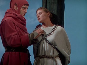 Movie still from “Joan of Arc” (1948), directed by Victor Fleming – A man and a woman chained to a pole; Medium shot, Low angle