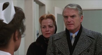 Movie still from “Joe” (1970), directed by John G. Avildsen – A man and a woman standing next to each other in a room; Close Up shot, Over the shoulder angle