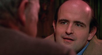 Movie still from “Joe” (1970), directed by John G. Avildsen – A man looking into a mirror while sitting down; Close Up shot, Over the shoulder angle