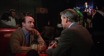 Movie still from “Joe” (1970), directed by John G. Avildsen – Two men sitting at a table talking to each other; Medium shot, Over the shoulder angle