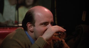 Movie still from “Joe” (1970), directed by John G. Avildsen – A bald man drinking a glass of beer; Close Up shot, Over the shoulder angle