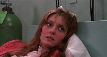 Movie still from “Joe” (1970), directed by John G. Avildsen – A woman with long red hair wearing a pink dress; Close Up shot, High angle