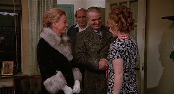 Movie still from “Joe” (1970), directed by John G. Avildsen – A group of people standing next to each other in a room; Medium shot, Over the shoulder angle