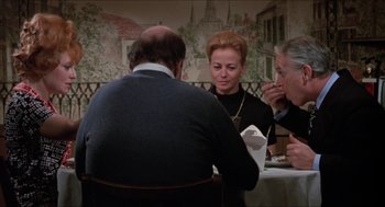 Movie still from “Joe” (1970), directed by John G. Avildsen – A group of people sitting at a table eating food; Medium shot, Over the shoulder angle