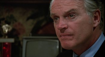 Movie still from “Joe” (1970), directed by John G. Avildsen – An older man in a suit and tie looking at the camera; Close Up shot, Low angle