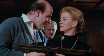 Movie still from “Joe” (1970), directed by John G. Avildsen – A man and a woman are holding a gun; Medium shot, Low angle