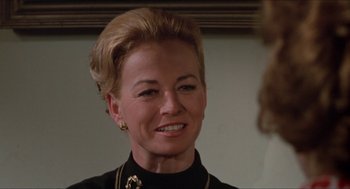 Movie still from “Joe” (1970), directed by John G. Avildsen – A woman with blonde hair wearing a black shirt; Close Up shot, Over the shoulder angle