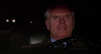 Movie still from “Joe” (1970), directed by John G. Avildsen – An older man wearing a suit and tie in a car; Close Up shot, Low angle