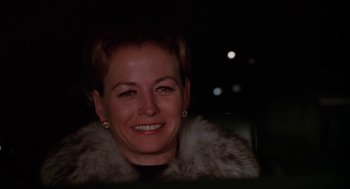 Movie still from “Joe” (1970), directed by John G. Avildsen – A woman with short red hair wearing a fur coat; Close Up shot, Over the shoulder angle