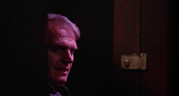 Movie still from “Joe” (1970), directed by John G. Avildsen – A person in a dark room; Close Up shot, Over the shoulder angle