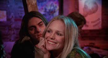 Movie still from “Joe” (1970), directed by John G. Avildsen – A woman smiles with her hand under her chin; Close Up shot, Low angle