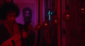 Movie still from “Joe” (1970), directed by John G. Avildsen – A group of people standing next to a wall with lights hanging; Medium shot, Low angle