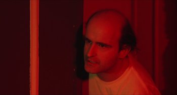 Movie still from “Joe” (1970), directed by John G. Avildsen – A man with a bald head is looking at the camera; Close Up shot, High angle