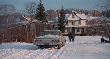 Movie still from “Joe” (1970), directed by John G. Avildsen – Two people walking in the snow next to an old car; Extreme Wide shot, Low angle