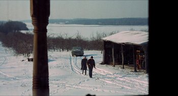 Movie still from “Joe” (1970), directed by John G. Avildsen – Two people are walking in the snow near a house; Extreme Wide shot, High angle