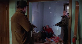 Movie still from “Joe” (1970), directed by John G. Avildsen – A group of people standing in a living room; Medium shot, Over the shoulder angle