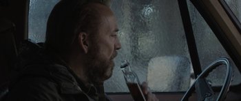 Movie still from “Joe” (2013), directed by David Gordon Green – A man with a beard is holding a glass of beer; Close Up shot, Over the shoulder angle