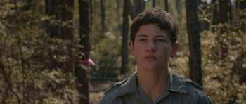 Movie still from “Joe” (2013), directed by David Gordon Green – A young man standing in the middle of a forest; Close Up shot, Low angle