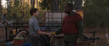 Movie still from “Joe” (2013), directed by David Gordon Green – Two men shaking hands in front of barrels of wine; Medium shot, Over the shoulder angle