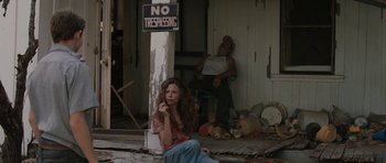 Movie still from “Joe” (2013), directed by David Gordon Green – A woman sitting in front of a no trespassing sign; Medium shot, Low angle