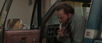 Movie still from “Joe” (2013), directed by David Gordon Green – A man sitting in the driver's seat of an old car; Medium shot, Over the shoulder angle