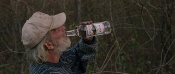 Movie still from “Joe” (2013), directed by David Gordon Green – An older man drinking a bottle of alcohol; Close Up shot, High angle