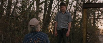 Movie still from “Joe” (2013), directed by David Gordon Green – A young man standing next to an older woman in the woods; Medium shot, Over the shoulder angle
