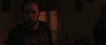 Movie still from “Joe” (2013), directed by David Gordon Green – A man standing in a dark room in front of a window; Close Up shot, Over the shoulder angle